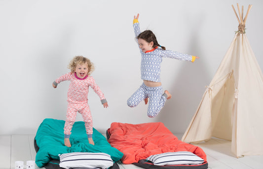 Young children jumping and playing games at a holiday campout in their living room