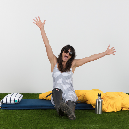 A happy camper wakes up after a great night's sleep on their luxury camping bed