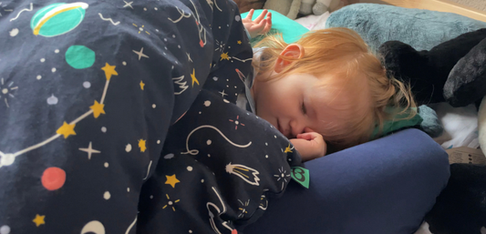A toddler sleeps soundly on the new Tot-to-Ten travel bed by Bundle Beds